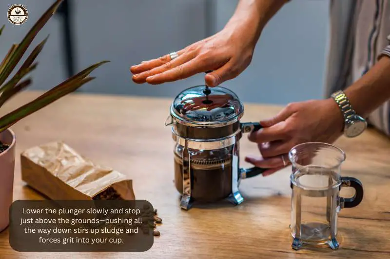 Lower the plunger slowly and stop just above the grounds—pushing all the way down stirs up sludge and forces grit into your cup.