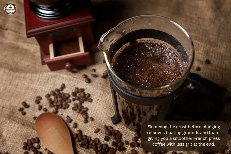 Skimming the crust before plunging removes floating grounds and foam, giving you a smoother French press coffee with less grit at the end.